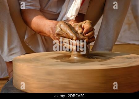 Töpferei - erfahrene Hände des Töpfers Formen der Ton auf Töpferrad Herstellung kleine Flasche. Topfwerfen. Herstellung traditionelle Handwerk indischen Glas, Stockfoto