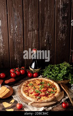 Rustikale hausgemachte Pizza mit scharfem Cheddar Chesse und würziger Salami Stockfoto