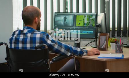 Disabled Freelancer Videofilmer Bearbeitung Postproduktion ein Videoprojekt Erstellung von Inhalten sitzen im Rollstuhl in modernen Büro. Creator Blogger arbeiten aus modernen Fotostudio. Stockfoto