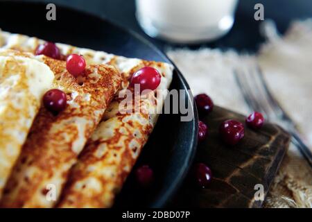 Nationale russische Küche. Pfannkuchen in einer Pfanne mit Milch. Rustikale Stilisierung eines einfachen Mittagessens. Stockfoto