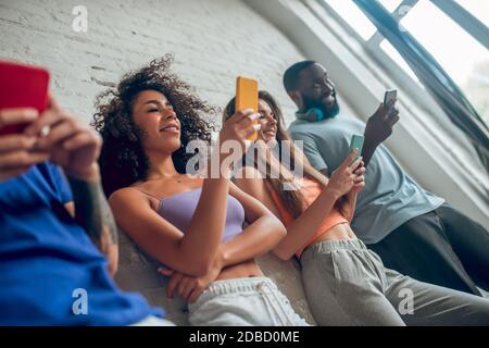 Drei Personen scrollen durch ihre Social-Media-Konten Stockfoto