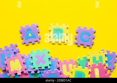 Alphabet Puzzle auf gelben Hintergrund. Ansicht von oben Stockfoto