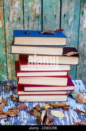 Stapel Bücher auf dem alten Tisch draußen Stockfoto