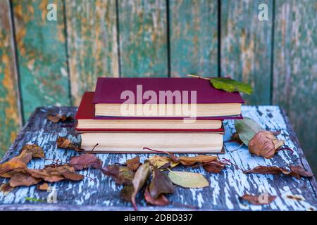 Stapel Bücher auf dem alten Tisch draußen Stockfoto