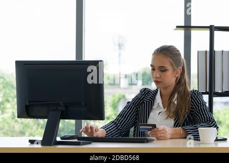 Teenager verbringen Zeit zwischen den Kaffeepausen, um Produkte online zu bestellen. Der Käufer füllt die Kreditkarteninformationen für die Bestellung aus. Stockfoto