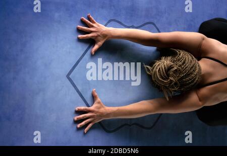 Junge athletische Frau tut Atemübungen und eine entspannende Pose. Haltung des Kindes. Horizontale Fotografie. Gesundheit und Yoga Konzept. Stockfoto