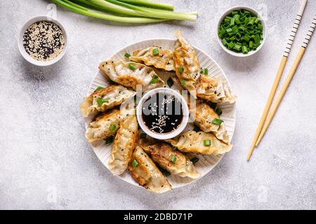 Gebratene Knödel Gyoza mit Sojasauce, und Essstäbchen, Draufsicht. Stockfoto