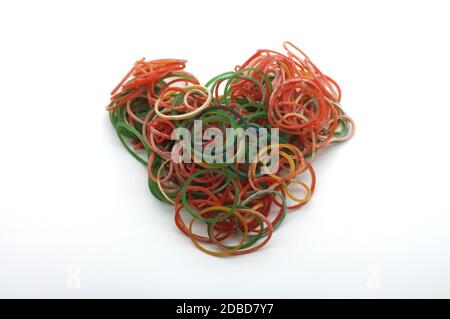 Bunte Gummibänder für die Herstellung Regenbogen Webstuhl Armbänder in Herzform isoliert auf weißem Hintergrund Stockfoto