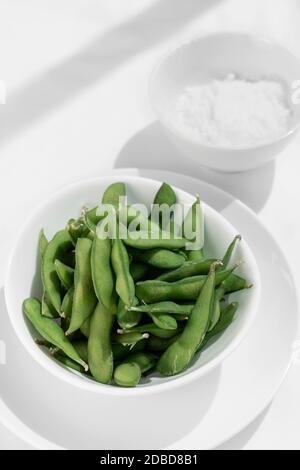 Bio Edamambohnen Snack in Schüssel auf dem Tisch mit Meersalz Stockfoto