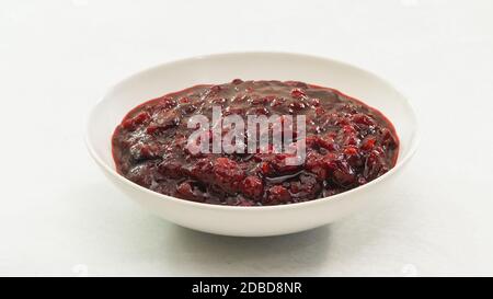 Frisch gekochte hausgemachte leckere Cranberry-Sauce aus der Nähe in einem Schüssel auf Küchentisch Stockfoto