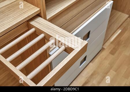 Interne Details der Holzgarderobe mit ausziehbarem Gestell für Kleiderständer. Eiche furnierte Sperrholzschränke mit hellgrau lackierten Schranktüren. Deta Stockfoto