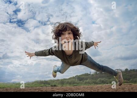 Freudiger Junge im Flug (Levitation-Effekt). Stockfoto