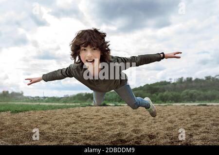 Freudiger Junge im Flug (Levitation-Effekt). Stockfoto