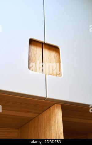 Detail der Garderobe Nahaufnahme. Moderne Holzgarderobe mit flachen Finger ziehen Schranktüren. Eiche furnierte Sperrholzschränke mit hellgrau lackiert ca. Stockfoto