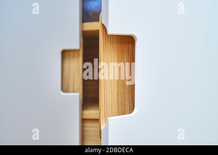 Detail der Garderobe Nahaufnahme. Moderne Holzgarderobe mit flachen Finger ziehen Schranktüren. Eiche furnierte Sperrholzschränke mit hellgrau lackiert ca. Stockfoto