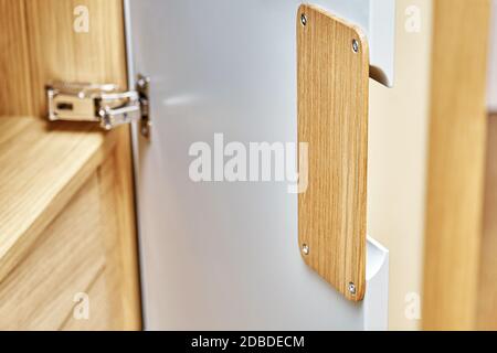 Detail der Garderobe Nahaufnahme. Moderne Holzgarderobe mit flachen Finger ziehen Schranktüren. Eiche furnierte Sperrholzschränke mit hellgrau lackiert ca. Stockfoto