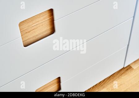 Detail der Garderobe Nahaufnahme. Moderne Holzgarderobe mit flachen Finger ziehen Schranktüren. Eiche furnierte Sperrholzschränke mit hellgrau lackiert ca. Stockfoto