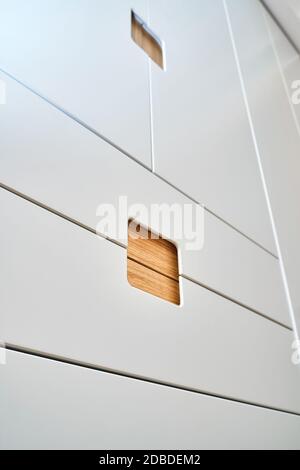 Detail der Garderobe Nahaufnahme. Moderne Holzgarderobe mit flachen Finger ziehen Schranktüren. Eiche furnierte Sperrholzschränke mit hellgrau lackiert ca. Stockfoto