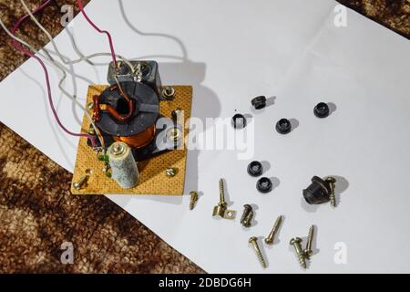 Akustischer Filter in einer Musiksäule. Elektrischer Stromkreis einer Magnetspule, Kondensator und Widerstand. Reparatur von akustischen Dynamiken, Ration Lötdraht Stockfoto