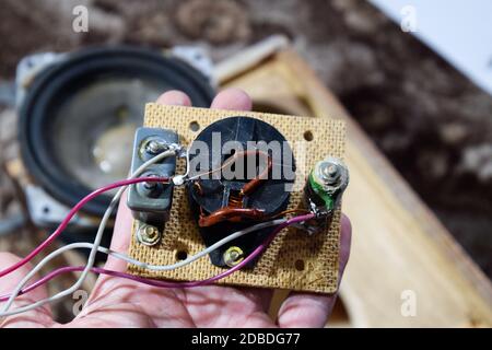 Akustischer Filter in einer Musiksäule. Elektrischer Stromkreis einer Magnetspule, Kondensator und Widerstand. Reparatur von akustischen Dynamiken, Ration Lötdraht Stockfoto