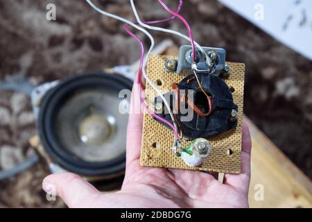 Akustischer Filter in einer Musiksäule. Elektrischer Stromkreis einer Magnetspule, Kondensator und Widerstand. Reparatur von akustischen Dynamiken, Ration Lötdraht Stockfoto