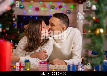 Heterosexuelle Paar umarmt in einem dekorierten Zimmer am Weihnachtstag Stockfoto