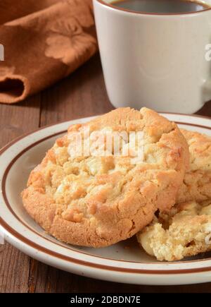 Gourmet-Macadamia-Nuss-Kekse und eine Tasse Kaffee Stockfoto