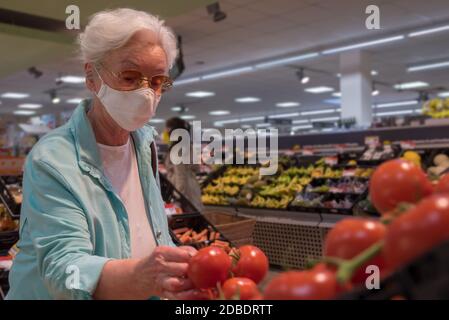 Ältere Frau mit Gesichtsmaske im Supermarkt Stockfoto