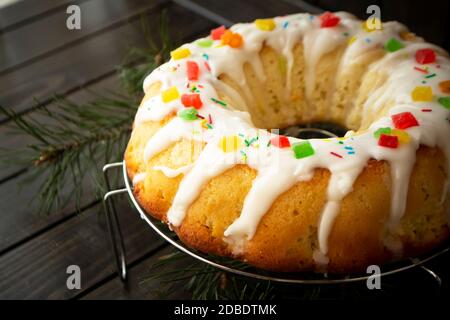 Brioche Teig oder Babka auf dunklem Holztisch mit Glasur Und farbenfrohe Dekoration Stockfoto