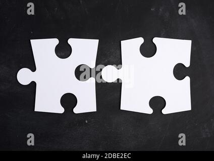 Leere weiße große leere Papier Rätsel auf einem schwarzen Hintergrund, Draufsicht, Kopierraum Stockfoto