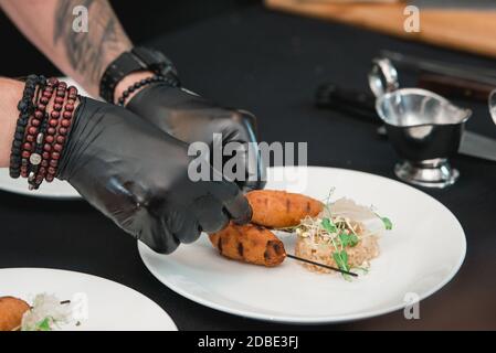 Küchenchef serviert saftige Fleischschnitzel mit einem Crisp on a Keramikplatte mit Reis Stockfoto