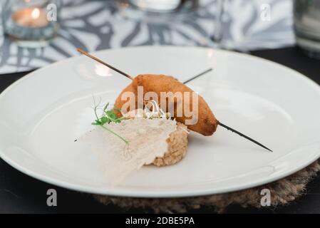 Küchenchef serviert saftige Fleischschnitzel mit einem Crisp on a Keramikplatte mit Reis Stockfoto