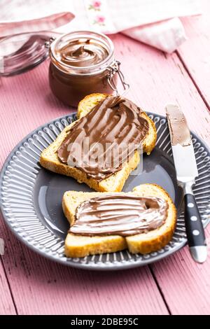 Toast Brot mit Haselnuss-Aufstrich. Süße Schokoladencreme auf dem Teller. Stockfoto
