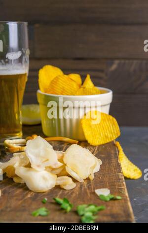 Getrockneter Oktopus mit Bier, Zitrone und Kartoffelchips auf dunklem Holzbrett. Snack auf Fisch mit Bier. Nahaufnahme. Stockfoto