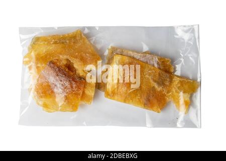 Getrocknetes Kabeljaufilet in einer transparenten Verpackung Vorspeise zu Bier auf weißem Hintergrund. Snack Fisch zu Bier. Nahaufnahme. Stockfoto