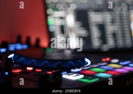 Seitenansicht eines DJ-Controllers mit DJ-Laptop im unscharfen Hintergrund Stockfoto