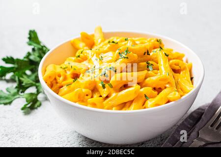 Mac und Käse in weißer Schale, grauer Hintergrund. Käse Pasta in einer Schüssel. Stockfoto