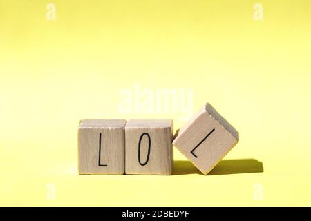 alphabet Holzblöcke bilden das Wort lol auf Retro Gelb Hintergrund, modernes Design close-up Stockfoto
