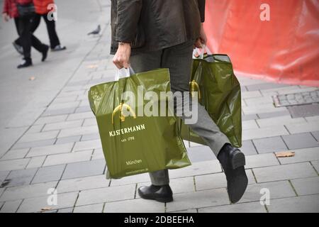 München, Deutschland. November 2020. Mann in Business-Kleidung trägt zwei Plastiktüten mit Einkaufsmöglichkeiten, Nutzung weltweit Credit: dpa/Alamy Live News Stockfoto