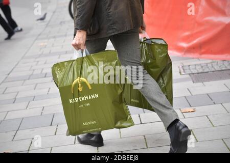 München, Deutschland. November 2020. Mann in Business-Kleidung trägt zwei Plastiktüten mit Einkaufsmöglichkeiten, Nutzung weltweit Credit: dpa/Alamy Live News Stockfoto