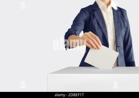 Frau einen Stimmzettel in eine Abstimmung Box setzen. Stockfoto