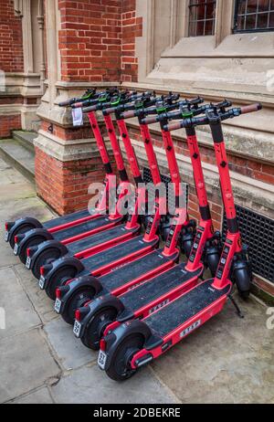 VOI Elektro-Scooter zu mieten auf einer Straße im historischen Zentrum von Cambridge. VOI Technology E-Scooter zum Mieten in einer Cambridge Straße. Stockfoto