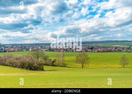 Eine Landschaft mit Wiesen und Feldern im Hintergrund sind drei Wolkenkratzer. Der Himmel wird durchzogen Stockfoto