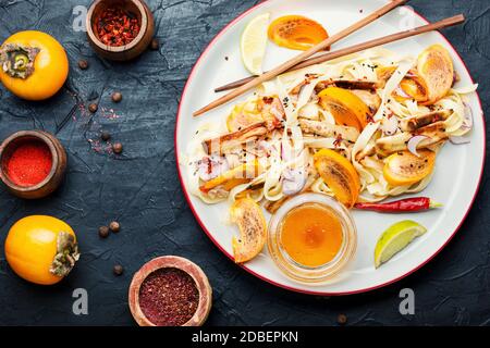 Orientalisches Essen, Salat mit Nudeln, Kaki und Auberginen. Gesunder asiatischer Salat Stockfoto