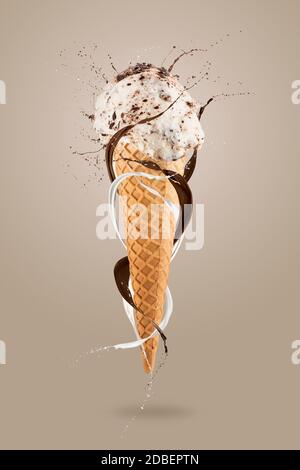 Stracciatella Eis-Kegel mit spritzender Milch herum, auf buntem Hintergrund Stockfoto