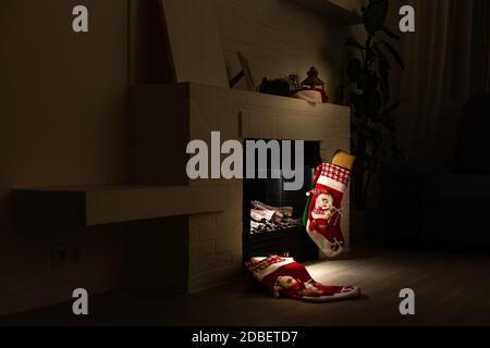 Weihnachtsstrumpf hängen von einem kaminsims oder Kamin, für Weihnachten dekoriert mit Feuer glühen. Stockfoto