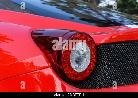 Nahaufnahme des linken Rücklichts eines Red Ferrari 458 Italia draußen bei Sonnenschein Stockfoto