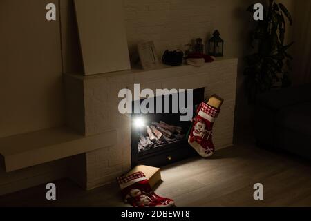 Weihnachtsstrumpf hängen von einem kaminsims oder Kamin, für Weihnachten dekoriert mit Feuer glühen. Stockfoto