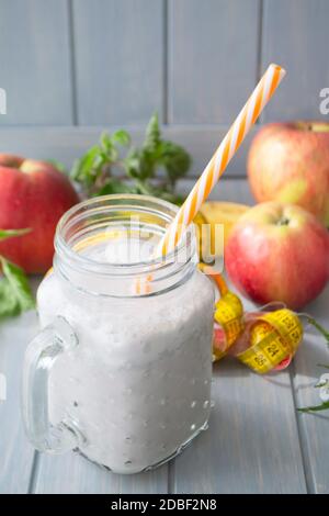 Smoothie aus Joghurt, Brennnessel, Apfel, Banane und Kräutern auf einem hellen Tisch. Vertikales Bild Stockfoto