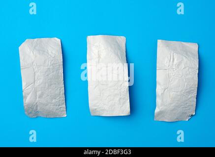 Verschiedene zerknitterte Folie verwendet candy Wrapper auf blauem Hintergrund, Ansicht von oben Stockfoto